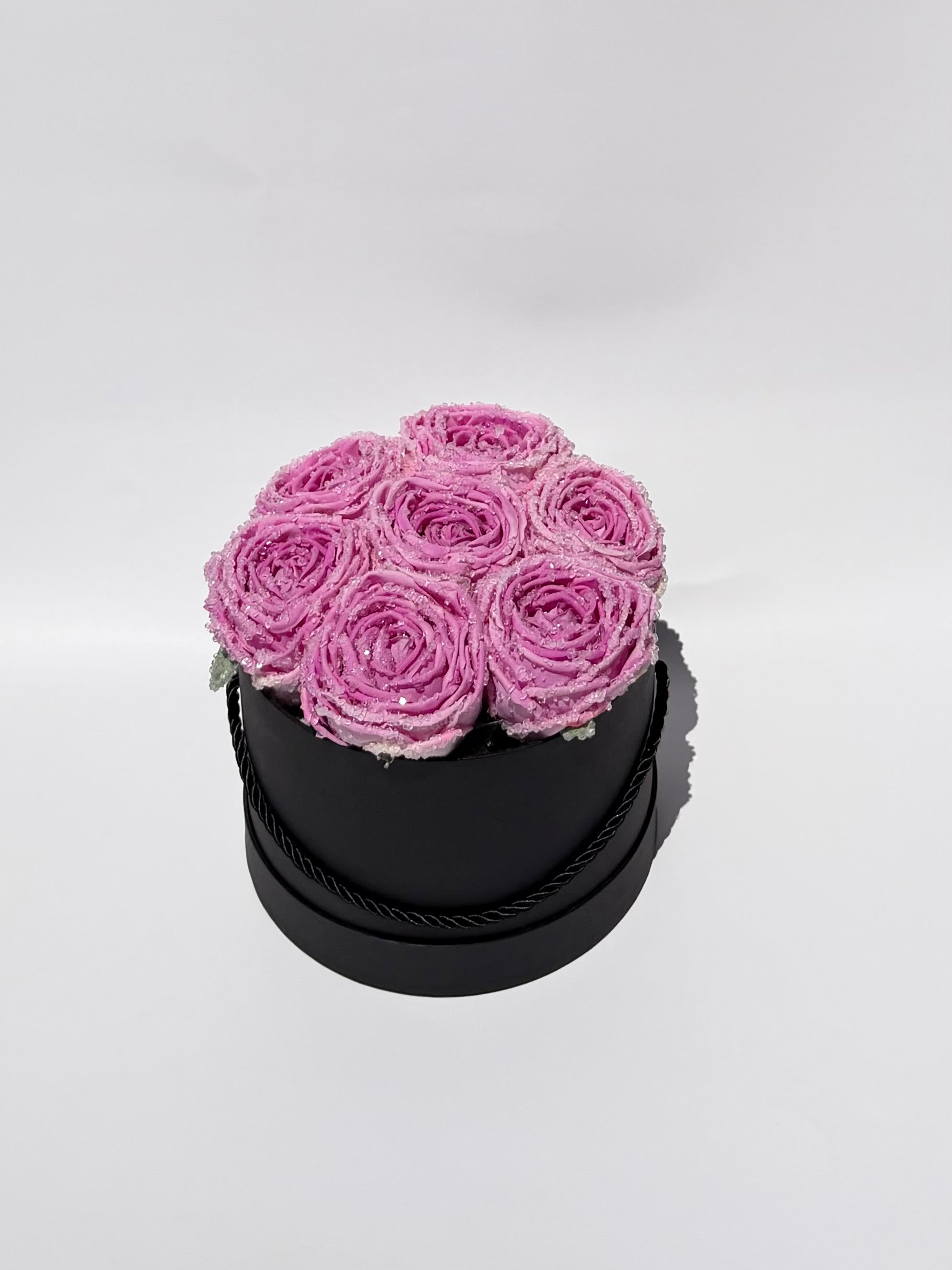 Black round box with pink roses on a white background