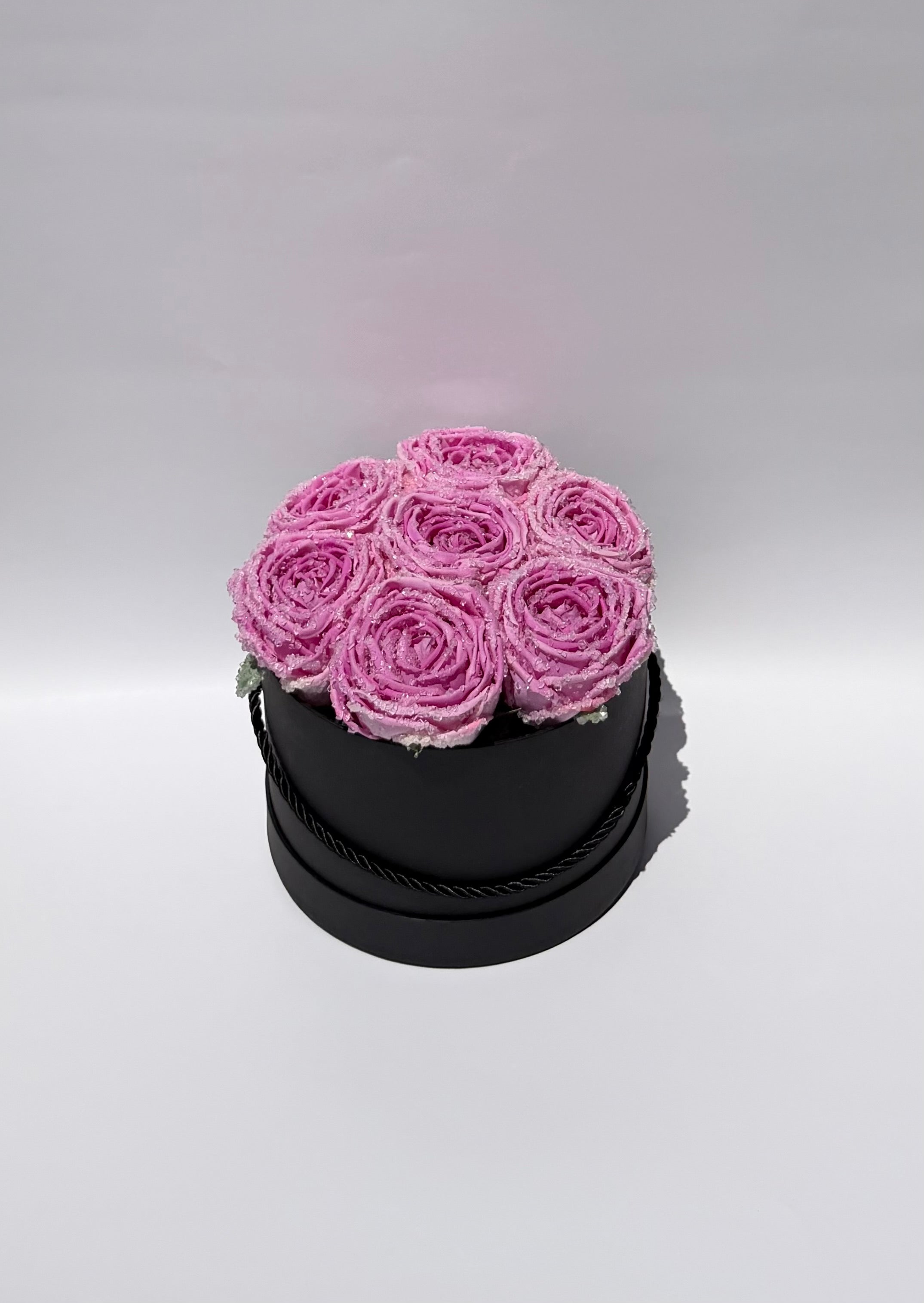 Black round box with pink roses on a light gray background