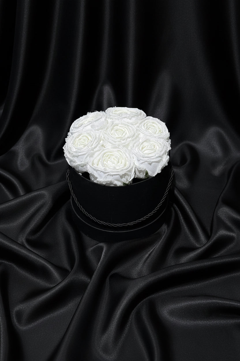 White roses in a black box on a black background